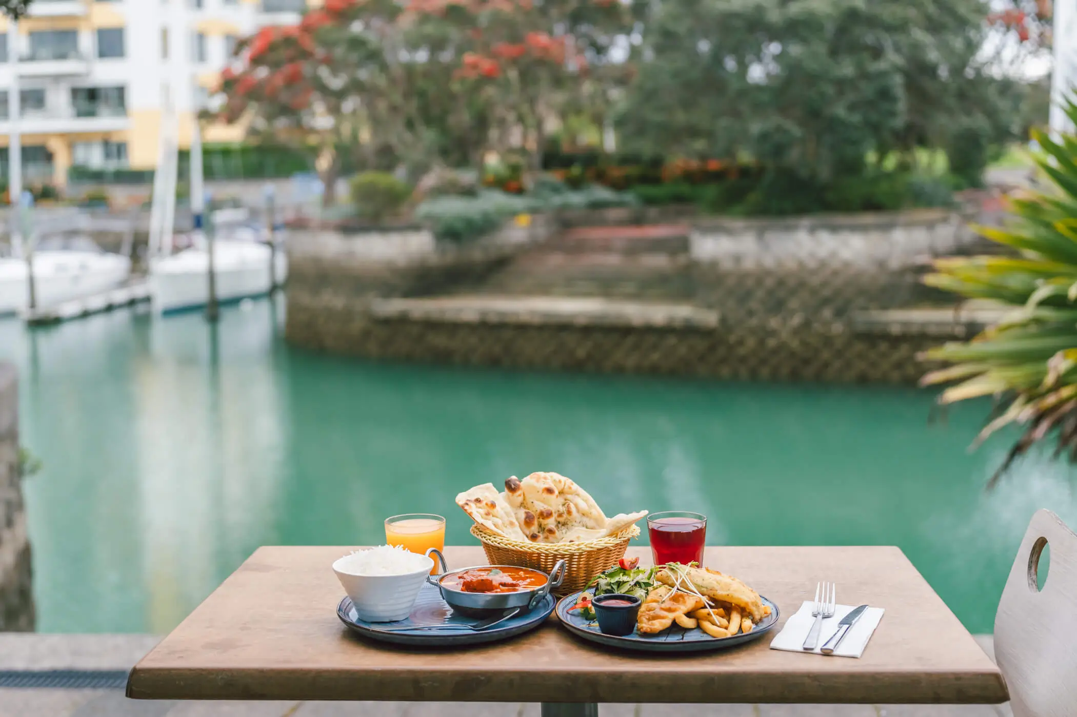 Food and drinks on a waterfront table overlooking the canal at Mainsail Bar and Bistro
