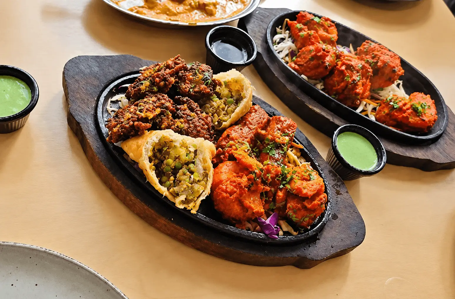 Assorted grilled food platters on hot plates